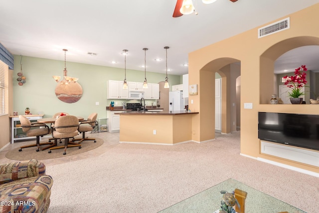 carpeted living room featuring sink and ceiling fan