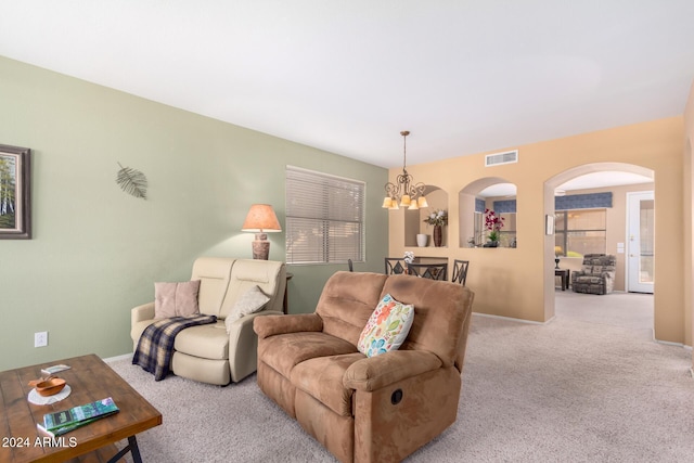 carpeted living room with a chandelier