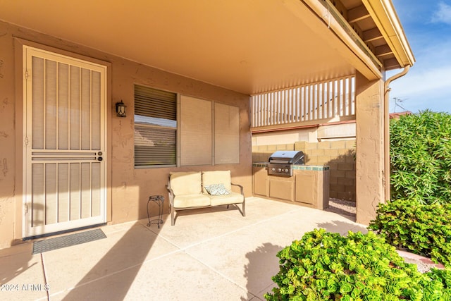 view of patio featuring exterior kitchen and a grill