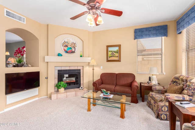 living room featuring carpet floors, ceiling fan, and a fireplace