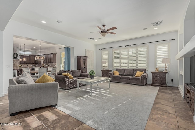 living room with a ceiling fan, plenty of natural light, recessed lighting, and baseboards