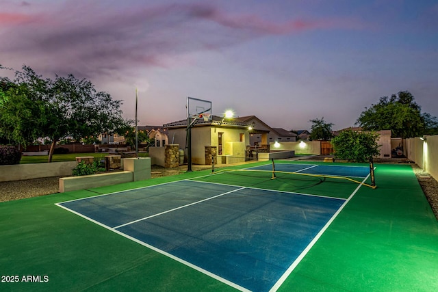 view of basketball court with a tennis court and fence