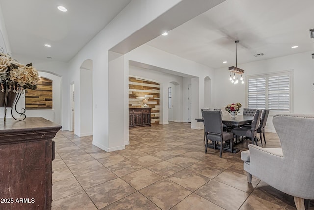 dining space featuring arched walkways, recessed lighting, baseboards, and a chandelier