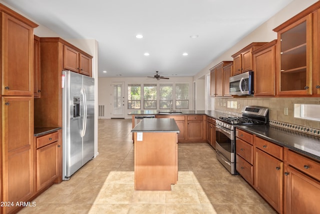 kitchen with a center island, appliances with stainless steel finishes, ceiling fan, and light tile flooring