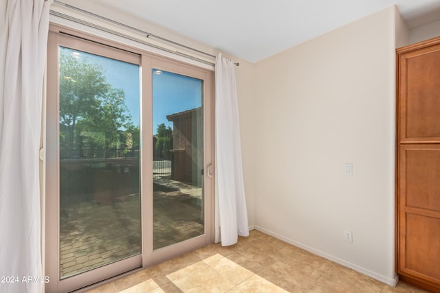 doorway to outside with light tile flooring