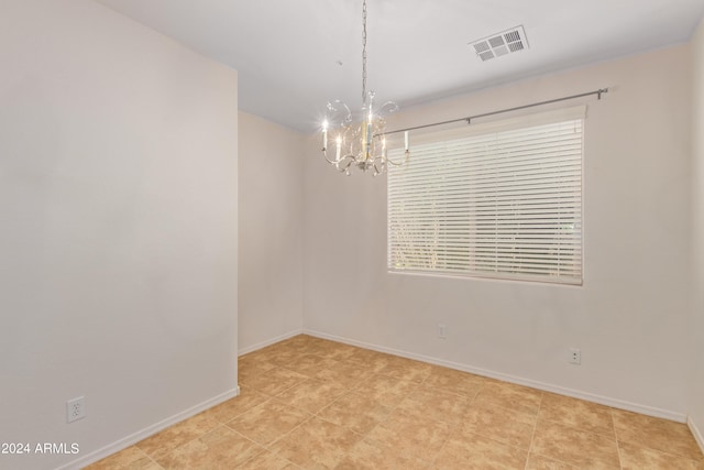 spare room with light tile flooring and an inviting chandelier