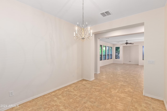 tiled empty room featuring ceiling fan with notable chandelier