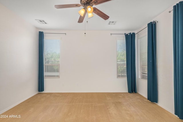 carpeted spare room with ceiling fan