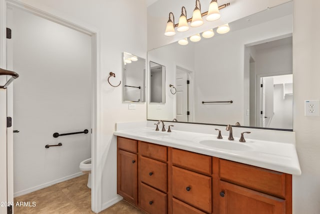 bathroom with double sink, toilet, tile floors, and large vanity