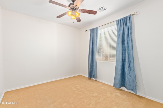 empty room featuring ceiling fan and carpet