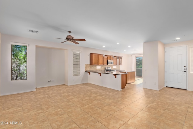 unfurnished living room with ceiling fan and light tile floors