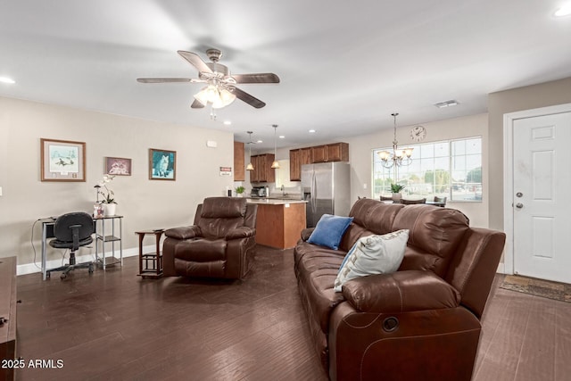 living room with dark wood-type flooring and ceiling fan with notable chandelier