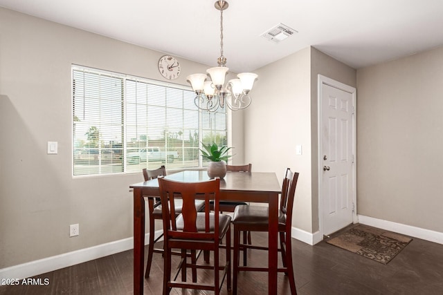 dining area featuring dark hardwood / wood-style flooring and a chandelier