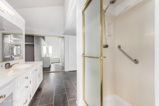 bathroom featuring vanity, a shower with shower door, and lofted ceiling