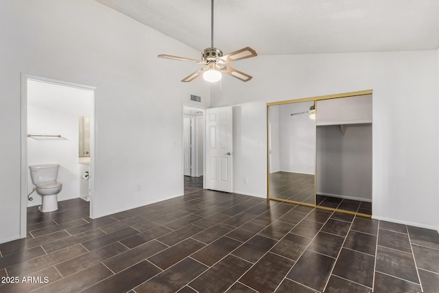 unfurnished bedroom with connected bathroom, ceiling fan, a closet, and high vaulted ceiling