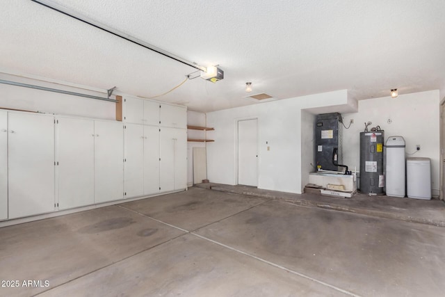 garage featuring heating unit, a garage door opener, and water heater