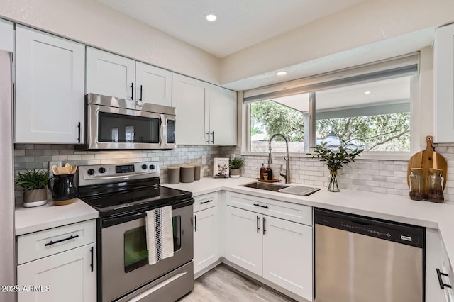 828 E Le Marche Ave, Phoenix, AZ 85022 - kitchen featuring stainless steel appliances, a sink, light countertops, white cabinetry, and recessed lighting