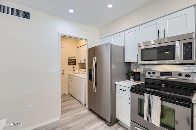 828 E Le Marche Ave, Phoenix, AZ 85022 - kitchen with stainless steel appliances, washing machine and clothes dryer, light wood finished floors, white cabinets, and recessed lighting
