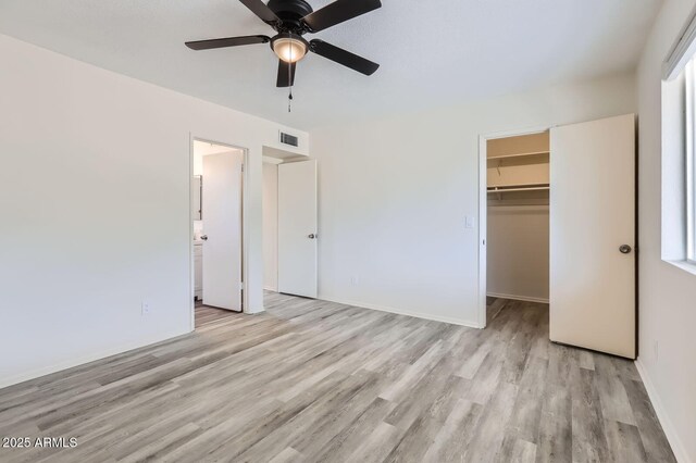 828 E Le Marche Ave, Phoenix, AZ 85022 - unfurnished bedroom with wood finished floors, a walk in closet, a closet, baseboards, and ceiling fan