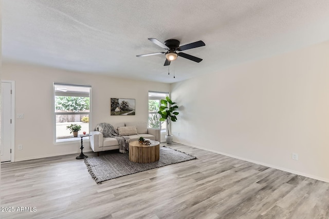 828 E Le Marche Ave, Phoenix, AZ 85022 - living room with light wood-style flooring, a ceiling fan, a textured ceiling, and baseboards