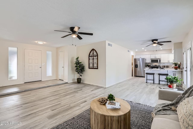 828 E Le Marche Ave, Phoenix, AZ 85022 - living area featuring a ceiling fan, light wood-type flooring, and baseboards