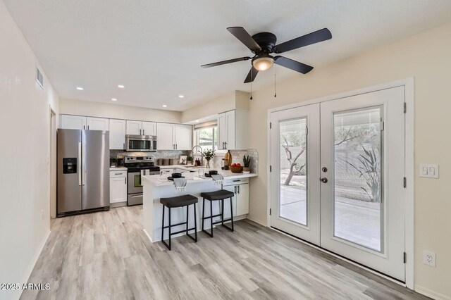 828 E Le Marche Ave, Phoenix, AZ 85022 - kitchen with stainless steel appliances, french doors, a peninsula, a sink, and light wood-type flooring