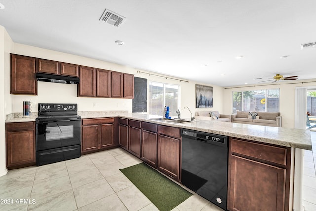 kitchen with a wealth of natural light, sink, kitchen peninsula, and black appliances