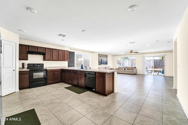 kitchen featuring sink, light tile patterned floors, dark brown cabinetry, and black appliances