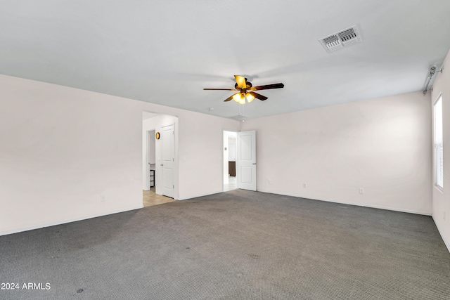 carpeted spare room featuring ceiling fan