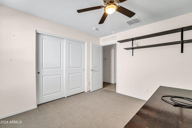 unfurnished bedroom with light colored carpet, ceiling fan, and a closet