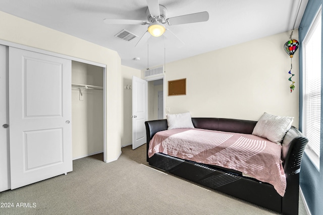 bedroom with light carpet, ceiling fan, and a closet