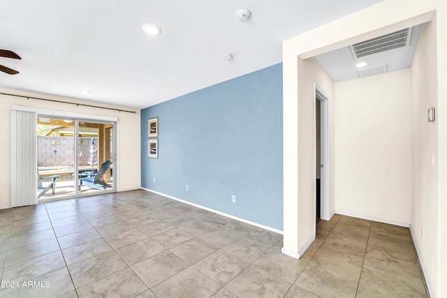 tiled spare room featuring ceiling fan