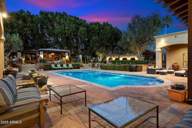 view of swimming pool featuring a patio, an outdoor living space with a fireplace, a fenced in pool, and a pergola