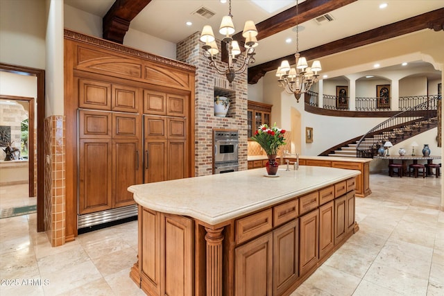 kitchen featuring beam ceiling, visible vents, light countertops, and an inviting chandelier