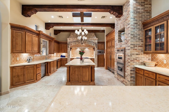 kitchen featuring stainless steel appliances, brown cabinets, visible vents, and a chandelier