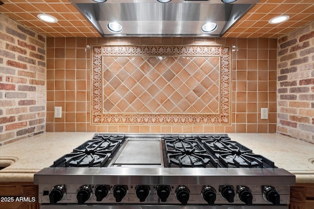 details with tasteful backsplash, range with gas cooktop, extractor fan, and light stone countertops