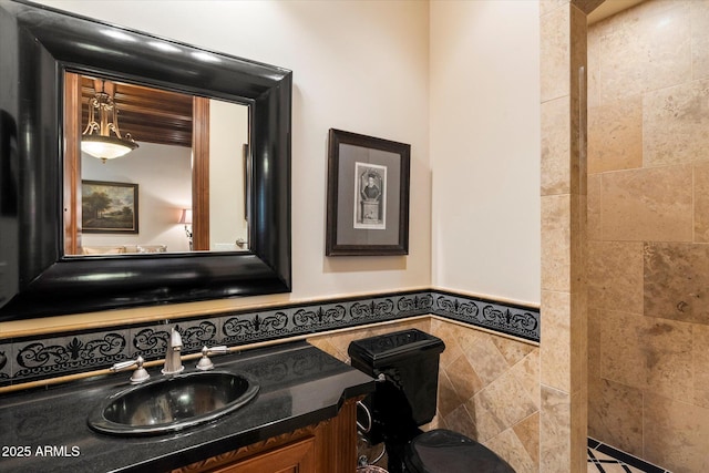 bathroom with wainscoting, tile walls, and vanity