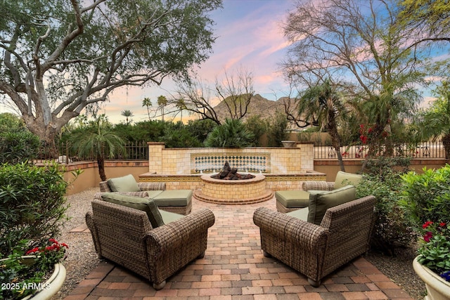 view of patio with an outdoor fire pit and fence