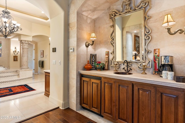 bathroom featuring tile patterned floors, decorative columns, tile walls, and vanity