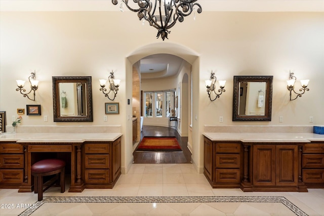 bathroom featuring tile patterned floors, baseboards, a notable chandelier, and vanity