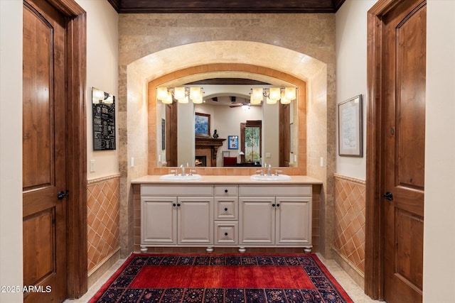 bathroom featuring wainscoting, tile walls, and a sink