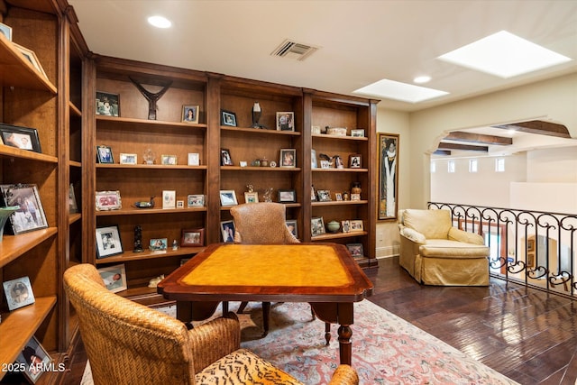 living area featuring dark wood finished floors, visible vents, recessed lighting, and a skylight