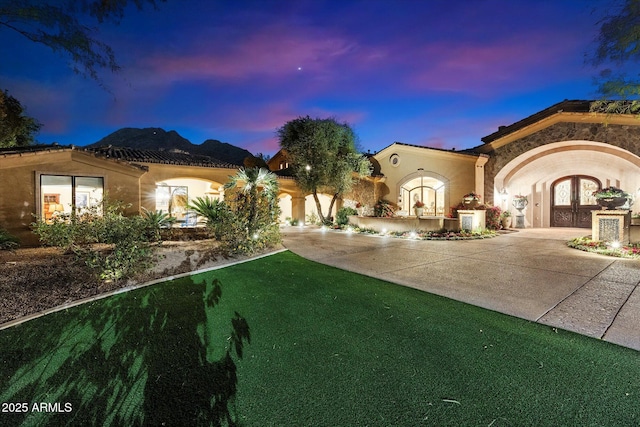 view of front of home with french doors, driveway, and stucco siding