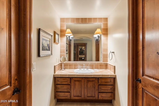 bathroom featuring baseboards, backsplash, and vanity