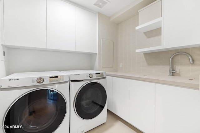 clothes washing area with cabinet space, washing machine and dryer, and visible vents