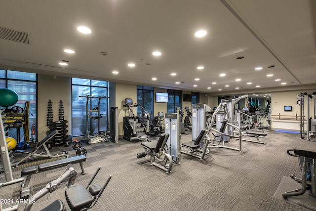 gym with a wall of windows, carpet, visible vents, and recessed lighting