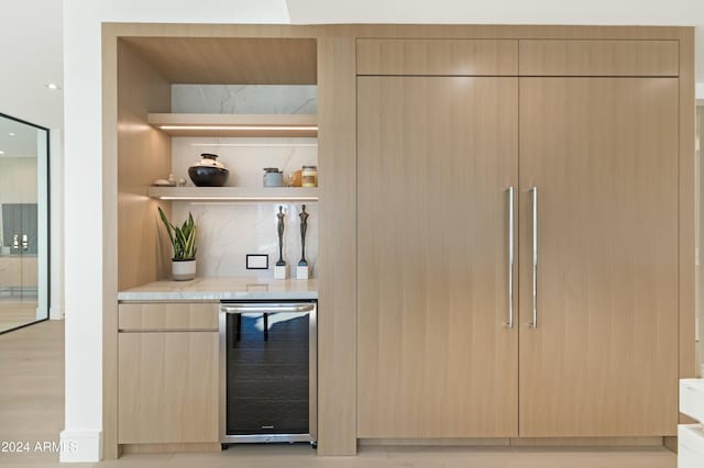 bar with beverage cooler, tasteful backsplash, paneled built in fridge, and a dry bar