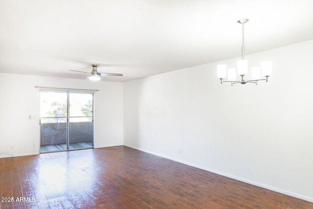 spare room featuring dark wood-type flooring, baseboards, and ceiling fan with notable chandelier