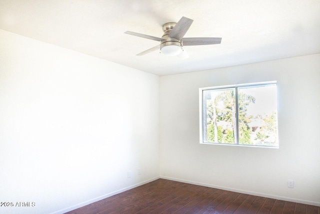 empty room featuring a ceiling fan, dark wood-style flooring, and baseboards