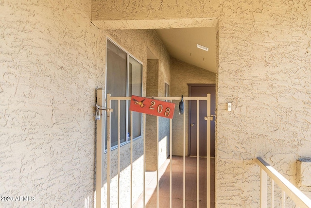 doorway to property with stucco siding and a gate